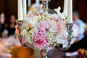 Candles burning in a chandelier on elegant dinner table