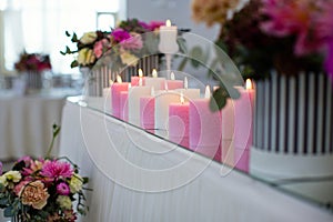 candles are burning ,white and pink candles stand on the table of the youth, festive decor of hall, table decoration for the