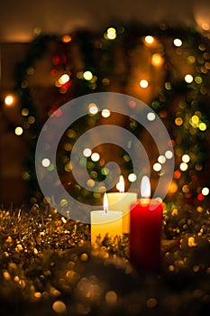 Candles and Christmas decorations on dark background with lights