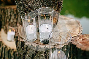 Candles in decorated goblets. Wedding decorations in rustic style. Outing ceremony. Wedding in nature.