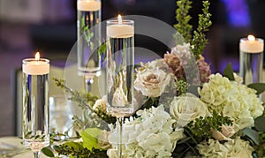 Candles floating in stemware and roses for wedding reception photo