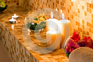 Candles and flowers on the tile in the bath