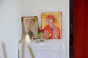 Candles in front of icons in the Orthodox church. A burning wax candles, cross and icons in monastery. Christian religion. Altar i