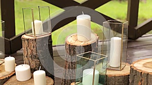 Candles in glass boxes standing on logs in wedding