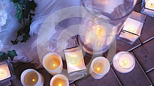 Candles in glass flasks at the evening celebration at the festive table. Wedding decor in the restaurant.