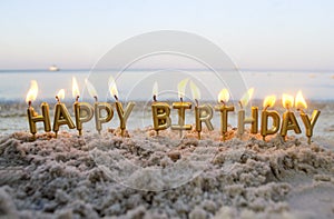 Candles Gold Letters Happy Birthday Burning on Background of Blurry Sea Waves