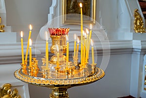 Candles at the icon in the Orthodox church. Religious holiday, great fasting, prayer concept