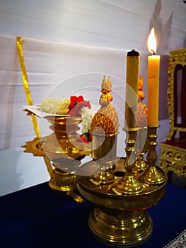 Candles, incense and offerings on brass containers with jasmine garland