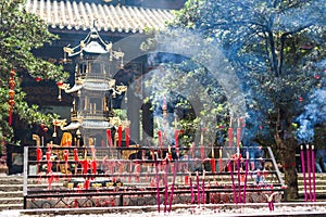 Candles and incense sticks burning in a buddhist temple