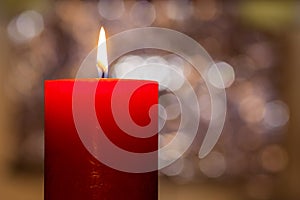 Candles light. Christmas candle burning at night. Abstract candle background. Golden light of candle flame. Closeup of a red