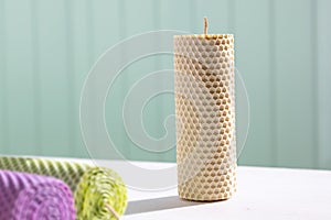 Candles made of beeswax on white table in sunny day