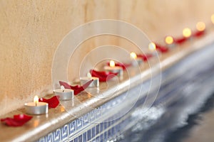 Candles and rose petals in a spa poolside relax concept