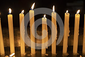 Candles on a row lit inside a church