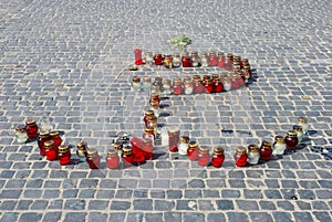 Candles on the street arranged in the shape of a symbol of Warsaw Uprising in 1944