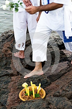 Candomble admirers are seen on top of a rock on the beach, paying homage to Iemanja with gifts