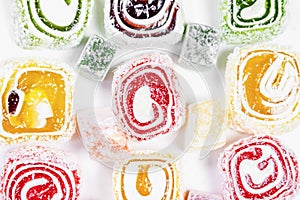 Candy background. Colored candy wrapped in a roll and sprinkled with coconut flake. Turkish delight