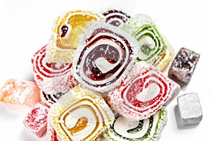 Candy background. Colored candy wrapped in a roll and sprinkled with coconut flake. Turkish delight
