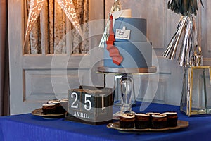 Candy bar with cupcakes, birthday cake with suit and tie design for a teenage boy, the Russian inscription reads Create Yourself.