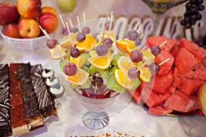 Candy bar.Different delicious fruits on wedding reception table with bananas and grapes