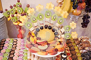 Candy bar.Different delicious fruits on wedding reception table with bananas and grapes