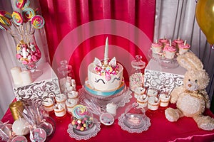 Candy bar for the first birthday for little baby girl. Sweet table and big unicorn cake