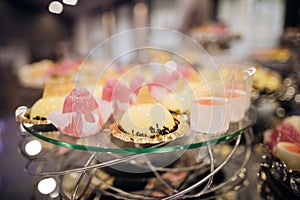 Candy bar, pink and yellow cake on wedding reception, catering food