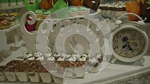 Candy bar. A table with sweet candies and cookies in green-orange tones on a white background.