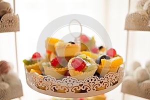 Sweet candy bar.Different delicious cake on wedding reception table with bananas and grapes photo