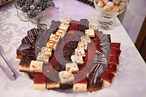 Sweet candy bar.Different delicious fruits and cookies on wedding reception table with bananas and grapes photo