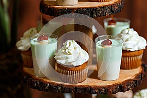 Candy bar on wooden wedding party with a lot of different candies, cupcakes, souffle and cakes