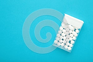 Candy in a box on blue background. Top view of the scattered dragees