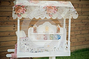 A candy buffet is set up at an outdoor wedding reception