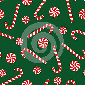 Candy cane and lollipop seamless christmas pattern on green background.