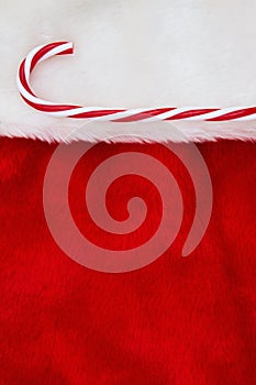 Candy cane on a red and white plush textured fabric Christmas stocking background