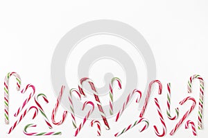 Candy canes border frame on white background. Top view, copy space