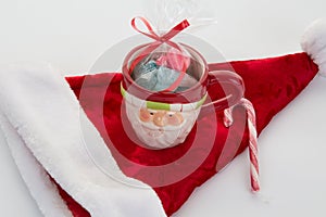 Candy canes, candies and chocolate on Santa hat isolated