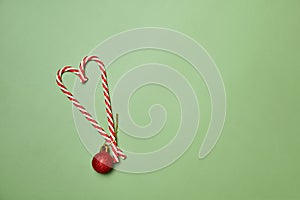 Candy Canes and red toy balls on green background