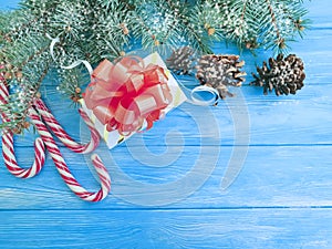 Candy, Christmas tree branch, vintage festive decoration border present snow gift box on a blue wooden background present