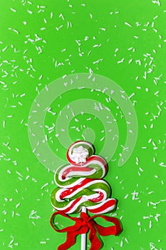 Candy Christmas tree and snowfall on green background
