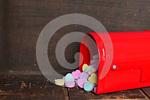 Candy conversation hearts spilling out of a red mailbox