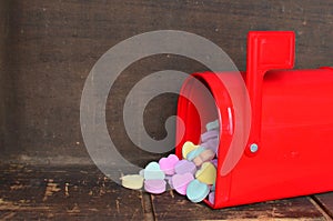 Candy conversation hearts spilling out of a red mailbox