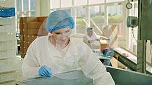 Candy factory. Factory worker checking packing machine.