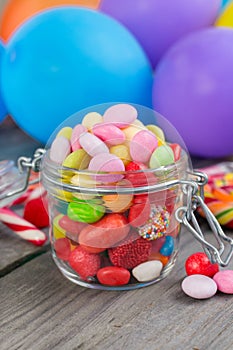 Candy in a glass jar on wooden table