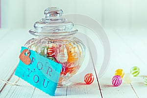 Candy jar filled with candies with a blue tag