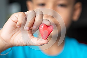 Candy red heart in hand a boy.