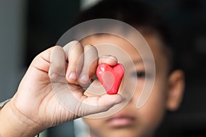 Candy red heart in hand a boy.