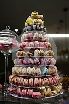 Candy shop display with colorful pyramid of French macarons biscuits