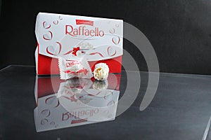 candy and a square rectangular gift box by Raffaello stands on a black background side view of copy space