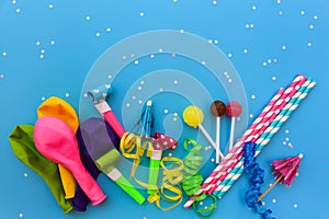 Candy, whistles, streamers, balloons on holiday table. Concept of children`s birthday party.