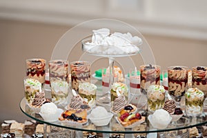 Candybar in a restaurant. Decorated white table fool of sweet pastry